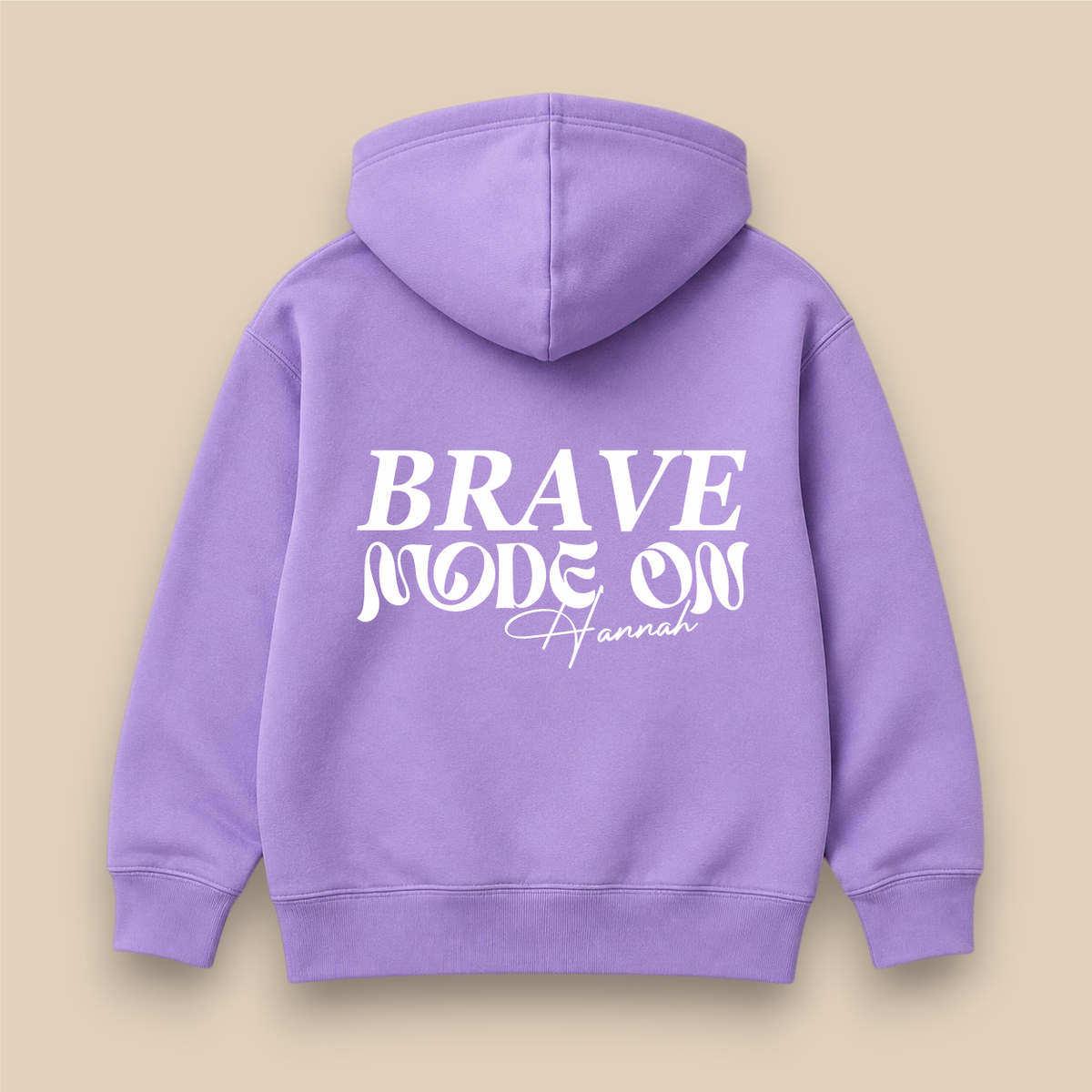 A Jack Spratt lavender hoodie shown from the back, featuring the text 'BRAVE MODE ON Hannah' printed in white. The hoodie is displayed flat against a solid beige background.