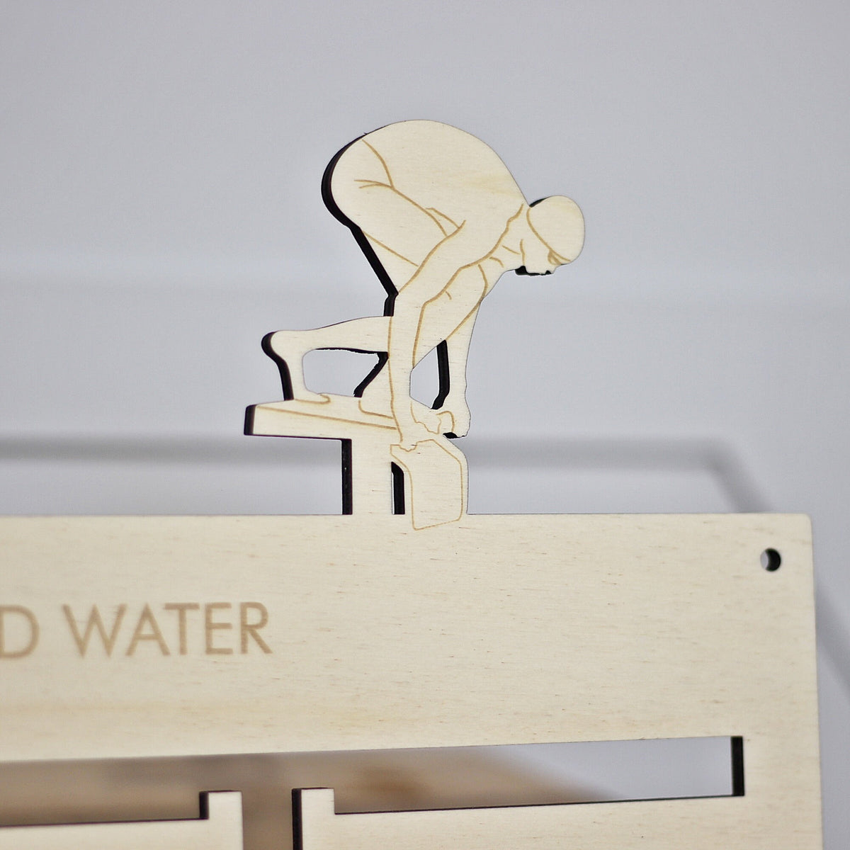 Wooden cutout of a person on a toilet with 'No Water' text on a light gray background