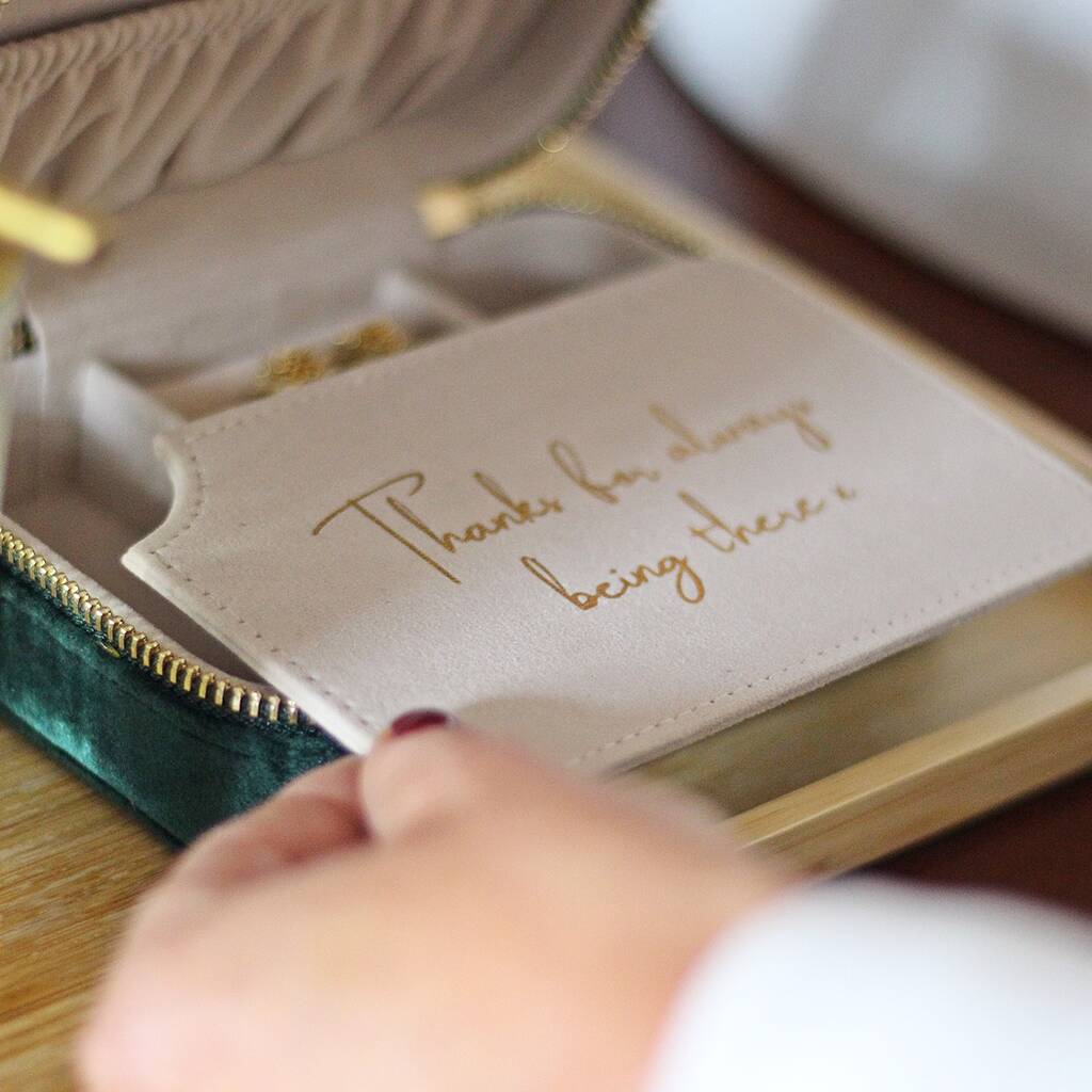 Jewelry box with a message card inside, held by a hand.