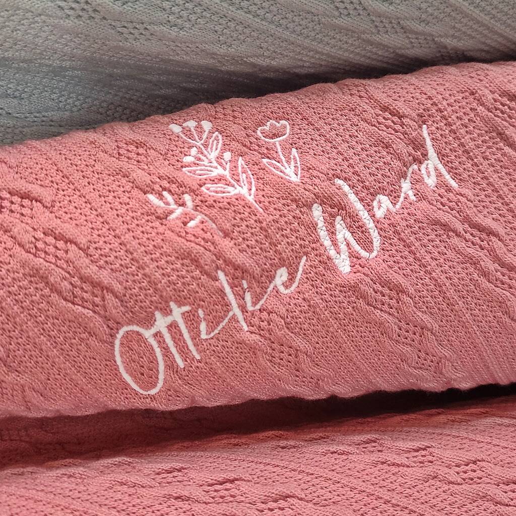 Pink textured blanket with embroidered name and decorative elements