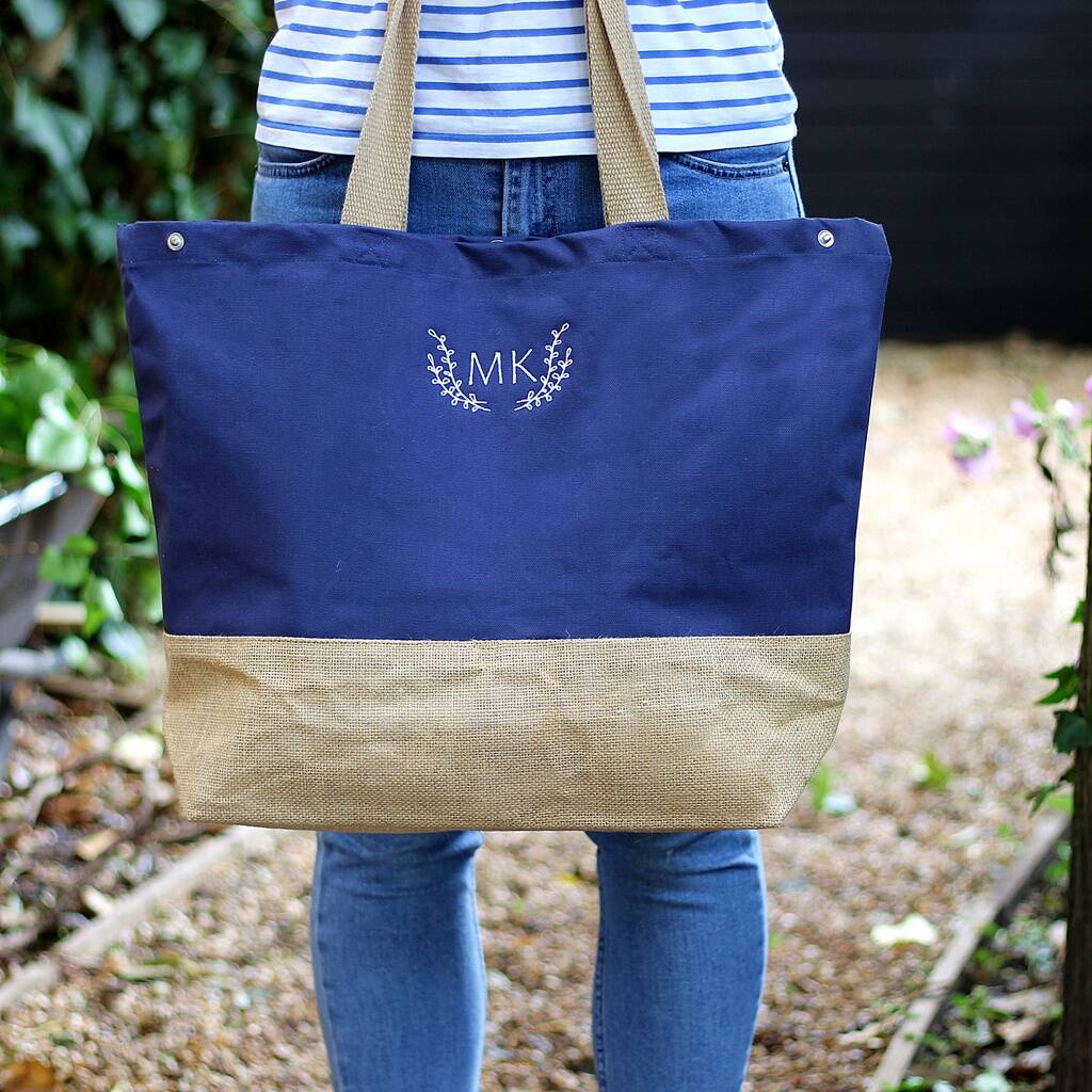 Navy tote bag with beige bottom section held by a person outdoors