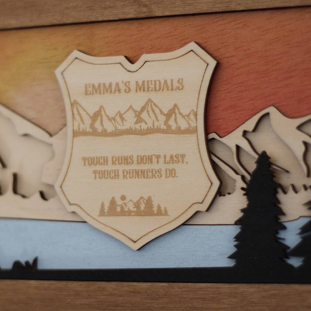 Wooden plaque with mountain design and text on a wooden background