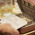 Jewelry box with personalized jewelry and a glass of champagne on a table.