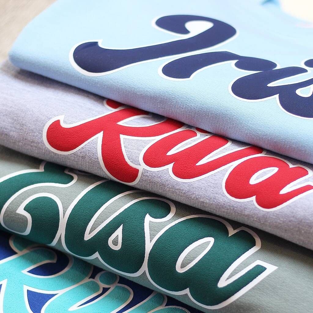 Three folded fabrics with 'Kiva' text in different colors on a light background