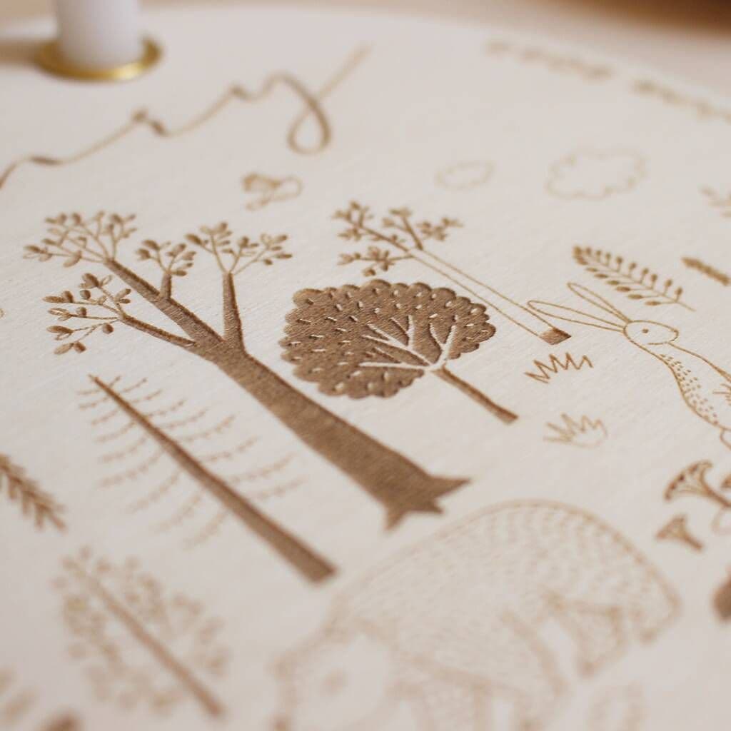 Close-up of a textured surface with engraved tree and leaf designs.