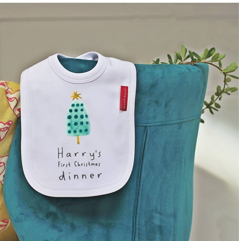 Baby bib with 'Harry's First Christmas dinner' text on a green blanket
