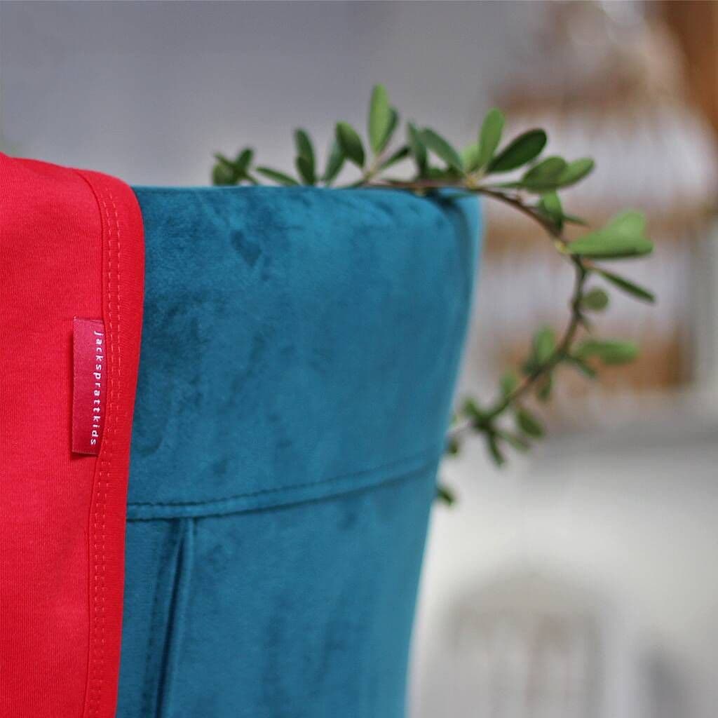 Red and blue fabric with a brand label against a blurred background