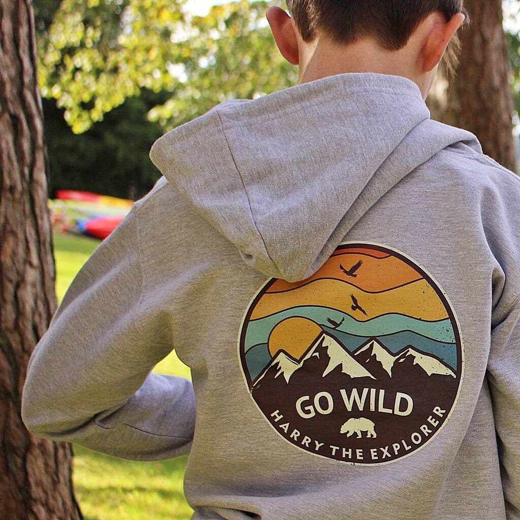 Person wearing a gray hoodie with 'Go Wild' design outdoors