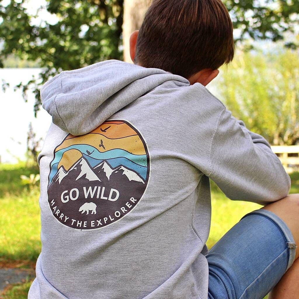 Person wearing a gray hoodie with 'Go Wild' and 'Harry the Explorer' design outdoors.
