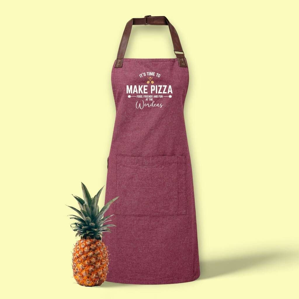 Purple apron with text next to a pineapple on a light yellow background