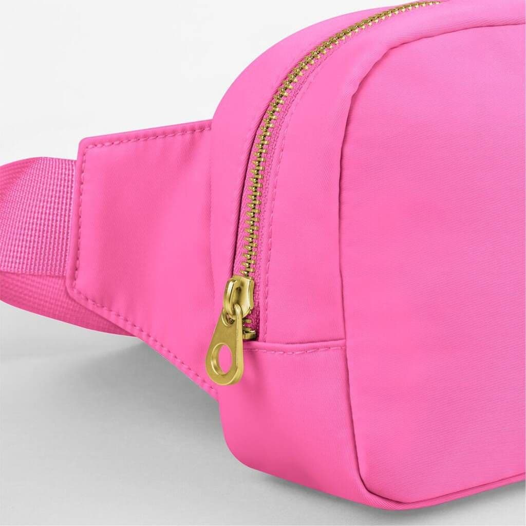 Pink waist bag with a gold zipper on a light gray background