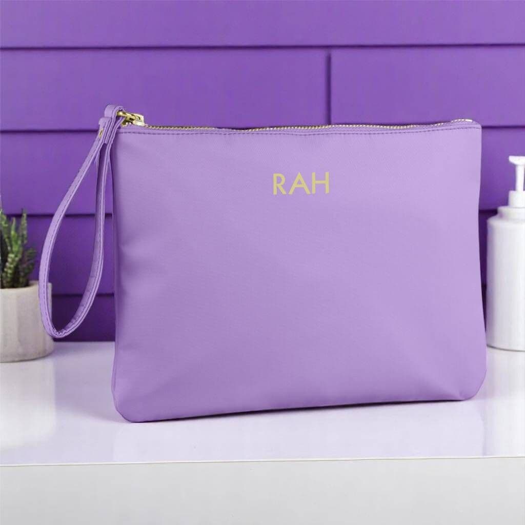 Purple pouch with 'RAH' initials on a white surface with a purple background
