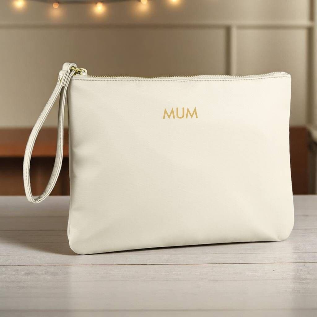 Beige pouch with 'MUM' embroidery on a wooden surface