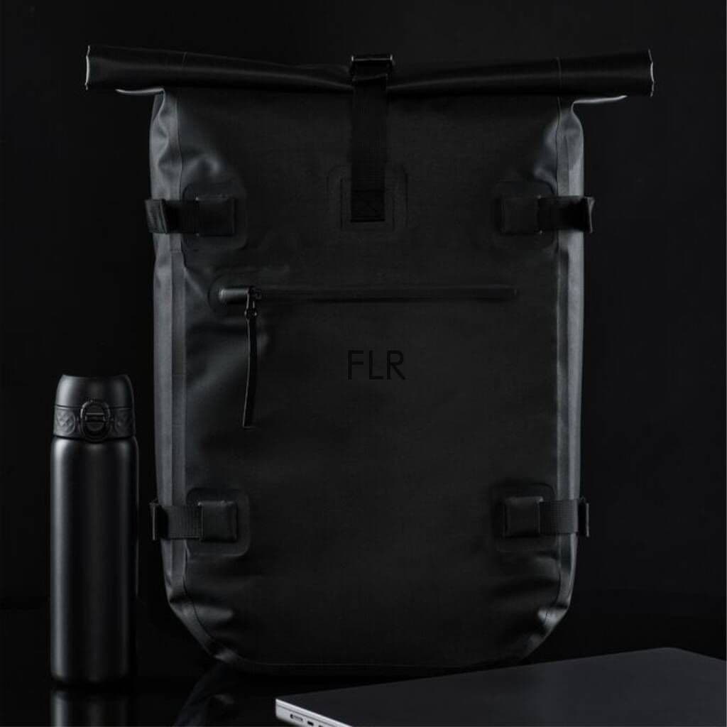 Black backpack with 'FLR' branding next to a black thermos on a dark background