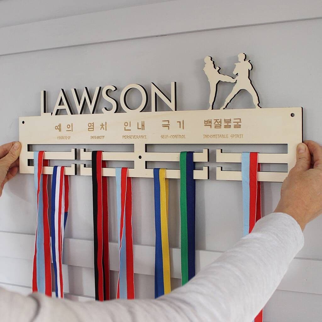 Wooden ribbon holder with ribbons and 'Lawson' branding on a white wall.